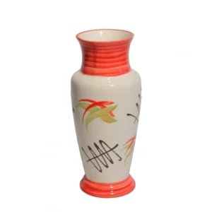A tall cream ceramic vase with hand-painted orange and green abstract designs holding a green trailing plant