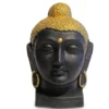 Front view of a matte black Buddha head statue with gold crown and earrings on a white background