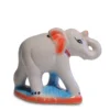 Hand-painted white ceramic elephant with red ears and a blue base, trunk raised for good luck
