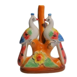 A hand-painted ceramic figurine featuring two white peacocks with floral patterns on a tree stump with a sunflower