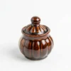 A handcrafted 200ml dual-tone ceramic jar with a glossy brown lid and top and a cream base, isolated on a white background.