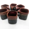 ceramic mugs by Vins Art House, featuring a dual-tone amber and black glaze with a textured honeycomb base, arranged on a white background.