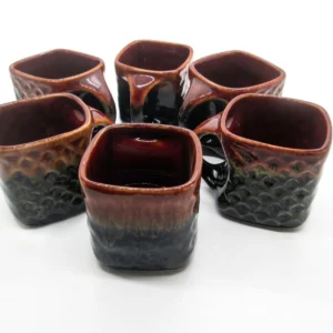 ceramic mugs by Vins Art House, featuring a dual-tone amber and black glaze with a textured honeycomb base, arranged on a white background.