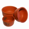 Close-up of the thick rim and rustic texture of a natural red clay cooking pot.