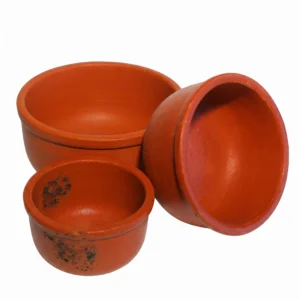 Close-up of the thick rim and rustic texture of a natural red clay cooking pot.