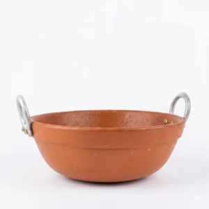Authentic red terracotta kadai chatti filled with steaming fish curry and green chilies.