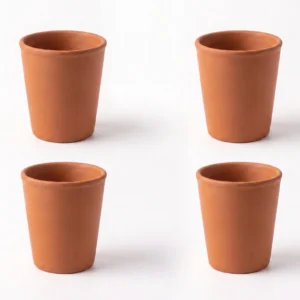 A set of four handcrafted red terracotta water cups arranged together on a white background.